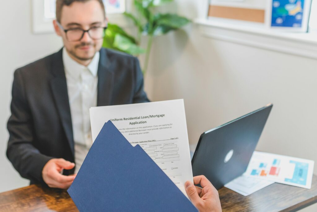 pexels-photo-8292879-8292879 Mortgage broker and client discussing loan application with documents on table.